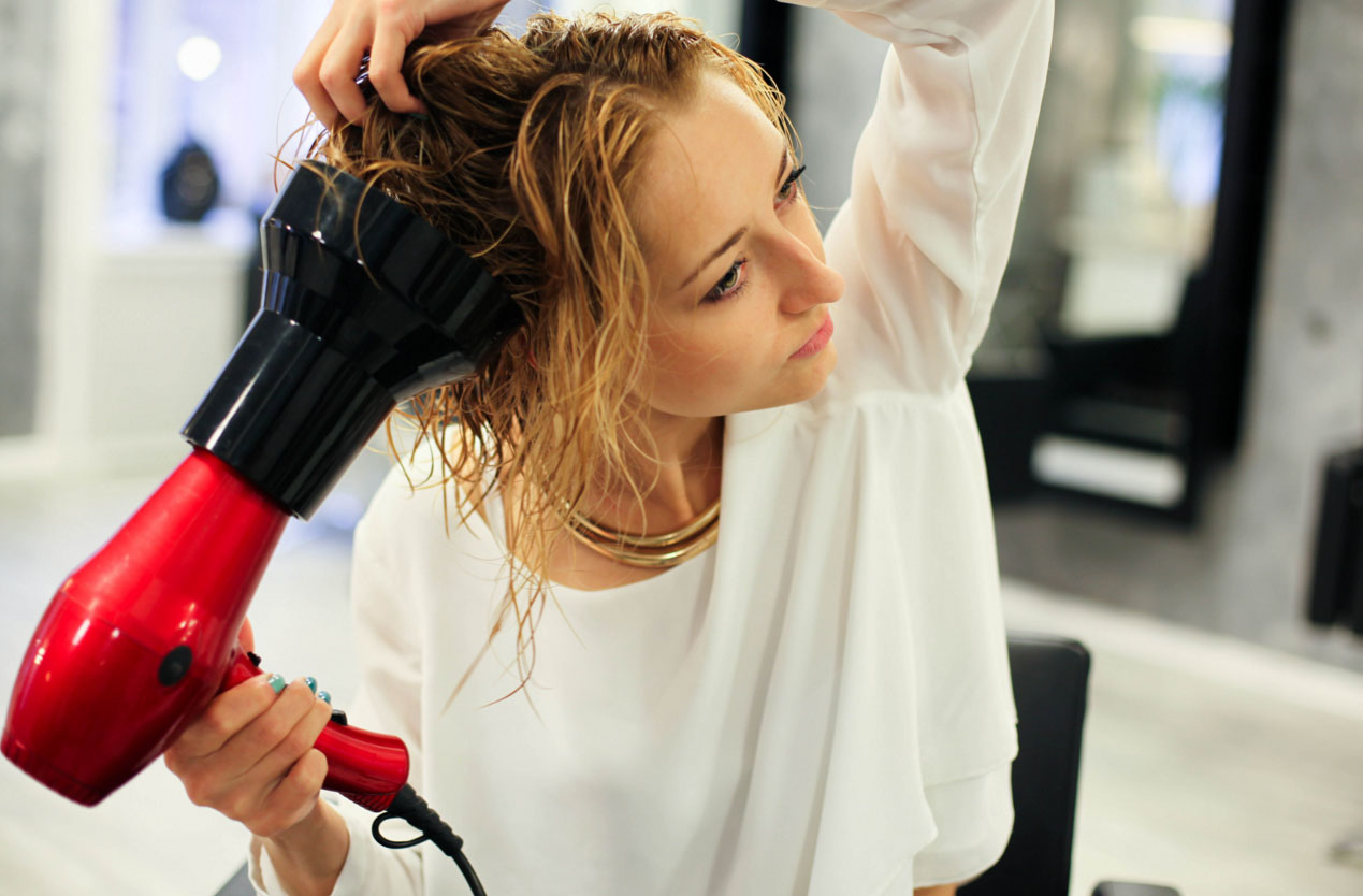 Девушка сущит волосы