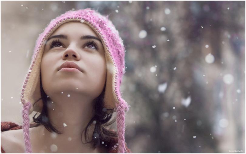 Девушка в шапке смотрит на снег