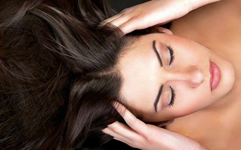 Темноволосая девушка с руками в волосах