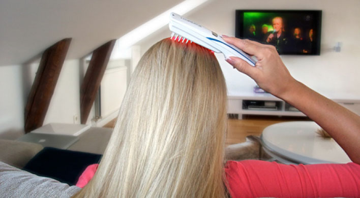 Беременная девушка расчесывает волосы лазерной расческой