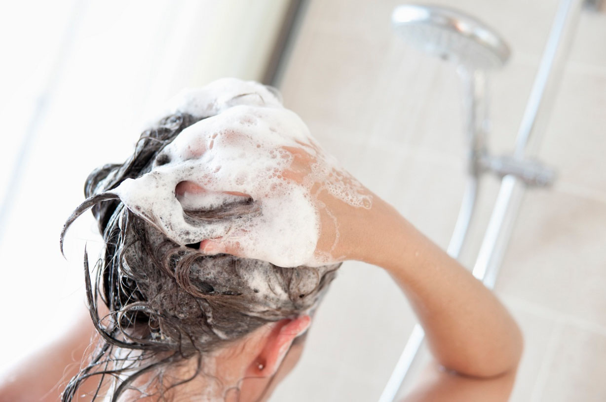 Девушка моет голову