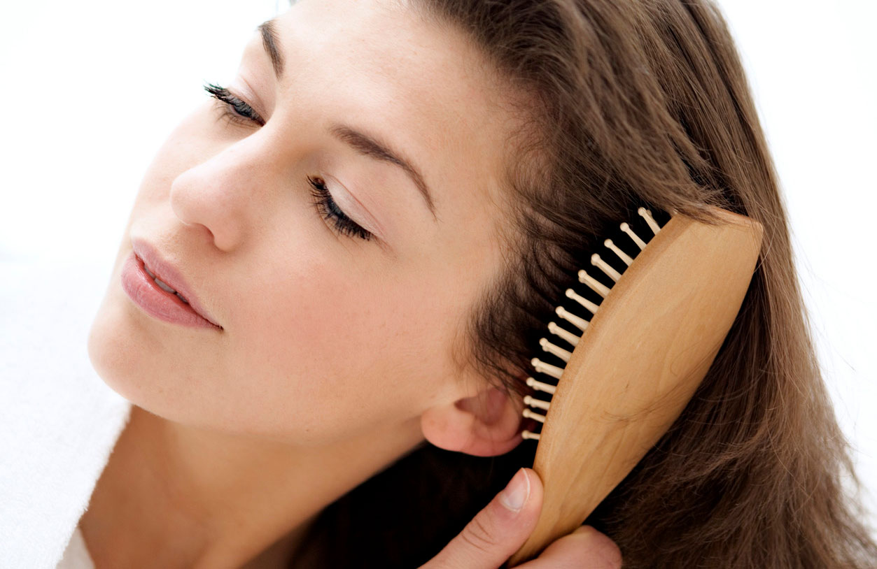 Девушка расчесывает волосы