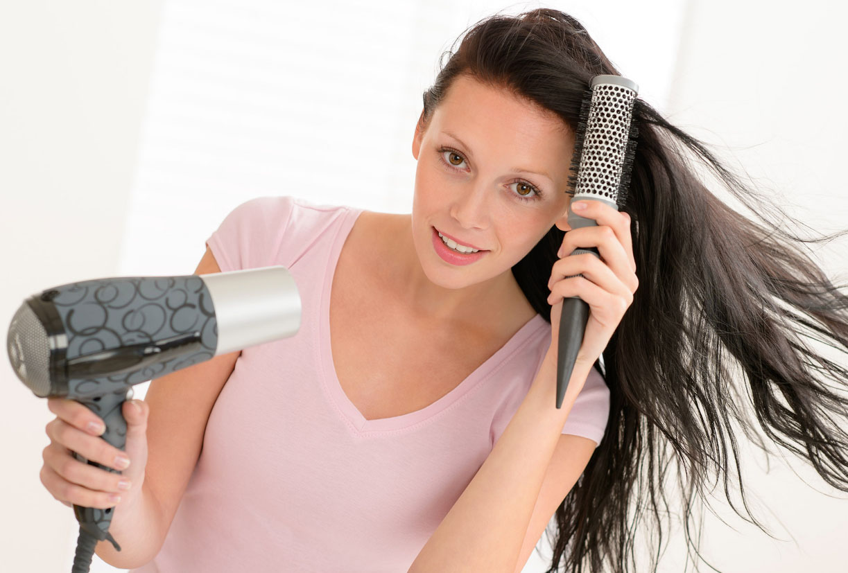 Девушка сушит волосы